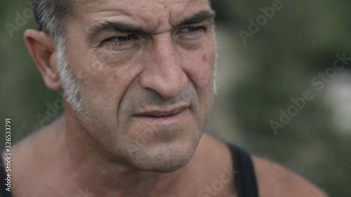 Portrait of handsome serious mature man with beard and grizzled long sideburns looking away thinking of life. Portrait of a middle aged biker. Hipster man.