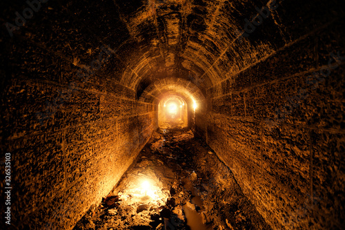 Dark and creepy old historical vaulted flooded underground drainage tunnel photo