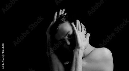 young man on a black background in a dramatic expressive pose