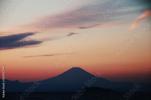 逗子海岸から見た 夕陽に霞む江の島と富士山と箱根遠景