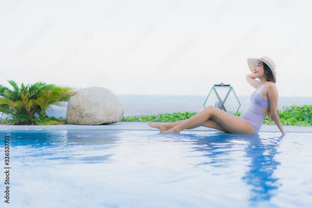 Fototapeta premium Portrait beautiful young asian woman happy smile relax around outdoor swimming pool in hotel resort