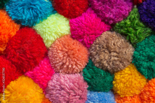 textured background of assorted and multicolored wool pom poms