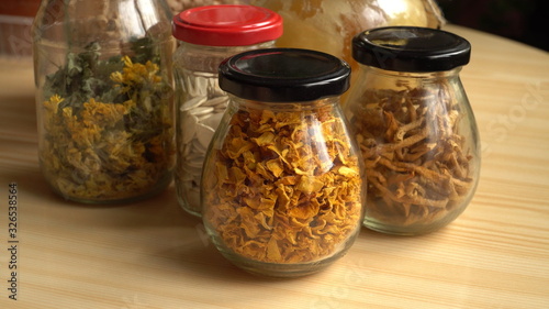 Natural food products of vegan placed in glass jars. Sun-dried vegetables - pumpkin seeds and peels as well as herbs as homemade spices and nutrition ingredients in the kitchen. Close-up scene.