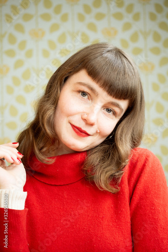 Portrait of a young red head woman having fun in front of a camera.