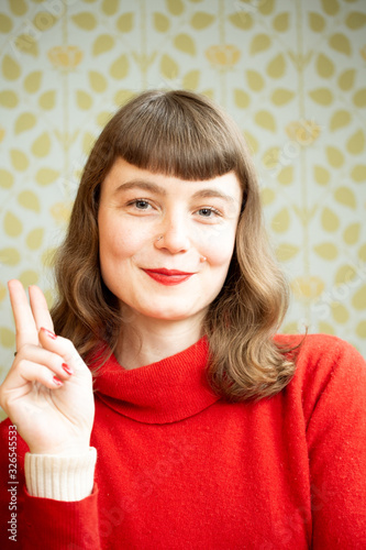 Portrait of a young red head woman having fun in front of a camera.