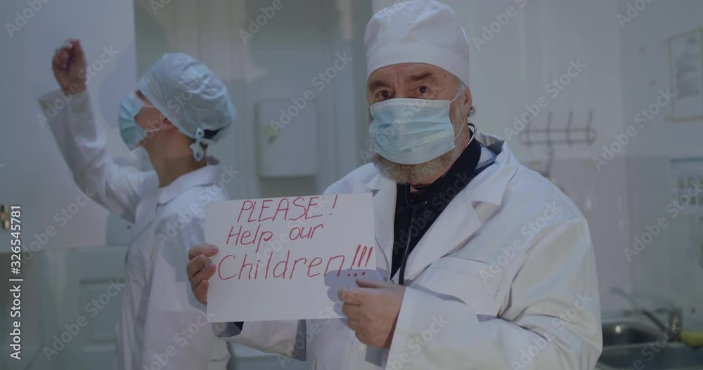 Portrait of doctor in uniform shows to camera a call on paper to help children Portrait of doctor in uniform shows to camera a call on paper to help children