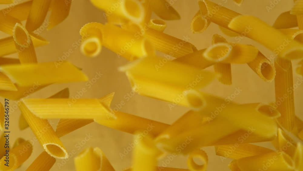 Super slow motion of flying uncooked italian pasta on golden background. Filmed on high speed cinema camera, 1000 fps. Super slow motion of flying uncooked italian pasta on golden background. Filmed on high speed cinema camera, 1000 fps.