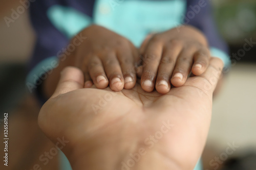close up of child hand over father hand 