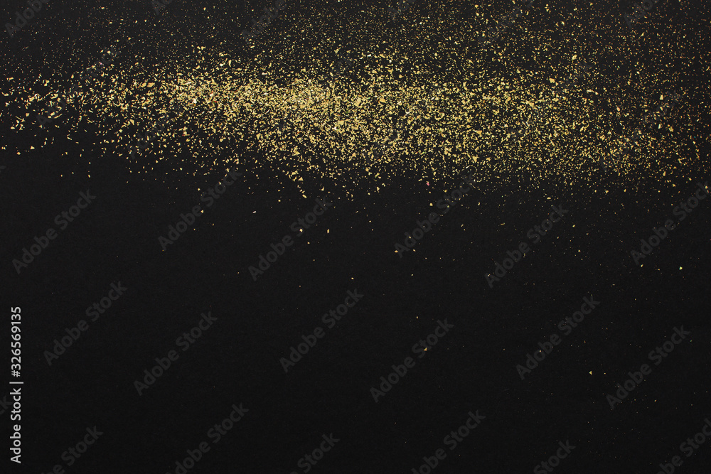 Gold glitter on black background. Holiday abstract texture