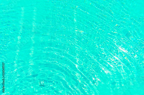 Surface of shining swimming pool water ripple in futuristic green toning. Perfect as a background for summer, vacation, calmness, serenity or any other idea.