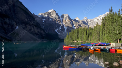 wide view of moraine lake and canoes in canada on a summer morning