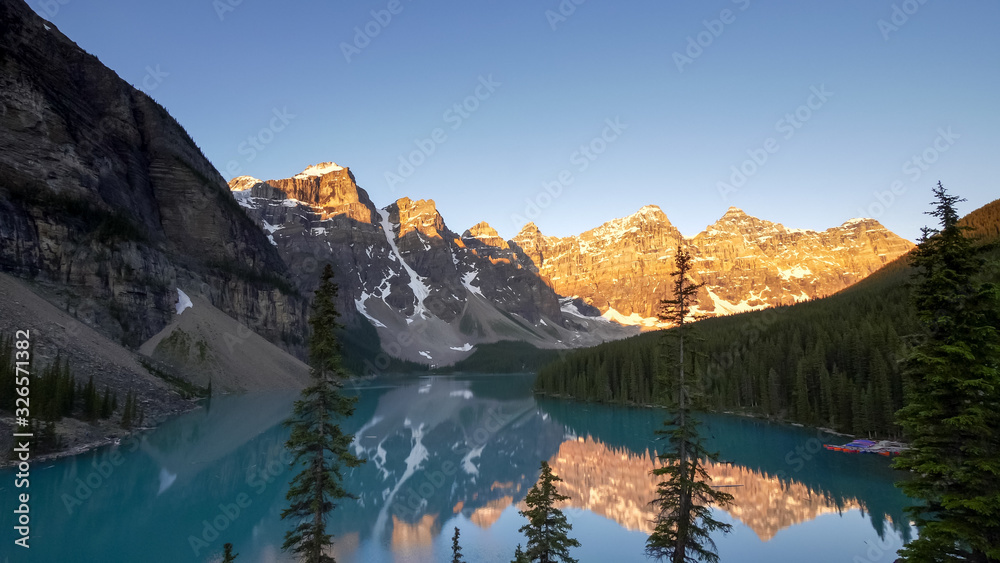 Fototapeta premium sunrise shot of moraine lake at pine trees in canada