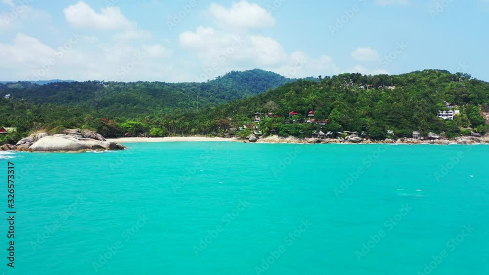 Haad Than Sadet Bay. Beautiful sunny day, crystal clear turquoise sea water and palms. secluded sandy beach with rocks on both side, Koh Pha Ngan. Thailand Haad Than Sadet Bay. Beautiful sunny day, crystal clear turquoise sea water and palms. secluded sandy beach with rocks on both side, Koh Pha Ngan. Thailand