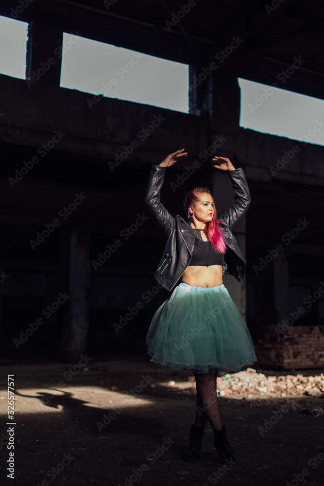 Portrait of a young girl with pink hair standing next to the bricks in a collapsed building