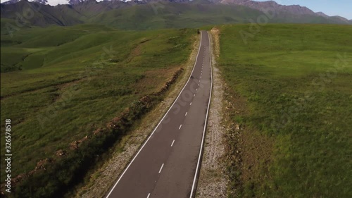 Empty serpentine road with fence, Kislovodsk - Dzhily Su asphalt dangerous beautiful winding freeway to Mount Elbrus in caucasus mountains at summer sunny morning - Aerial drone view photo