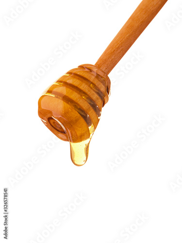 Isolated wooden honey stick and drops bee honey isolated on white background, close-up