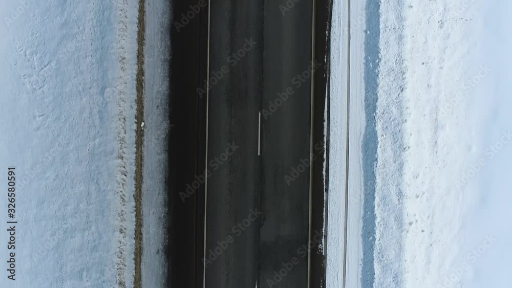 Empty road endless asphalt straight freeway in snow flat field / Aerial top down view, Highway trip without cars at winter sunny day Empty road endless asphalt straight freeway in snow flat field / Aerial top down view, Highway trip without cars at winter sunny day
