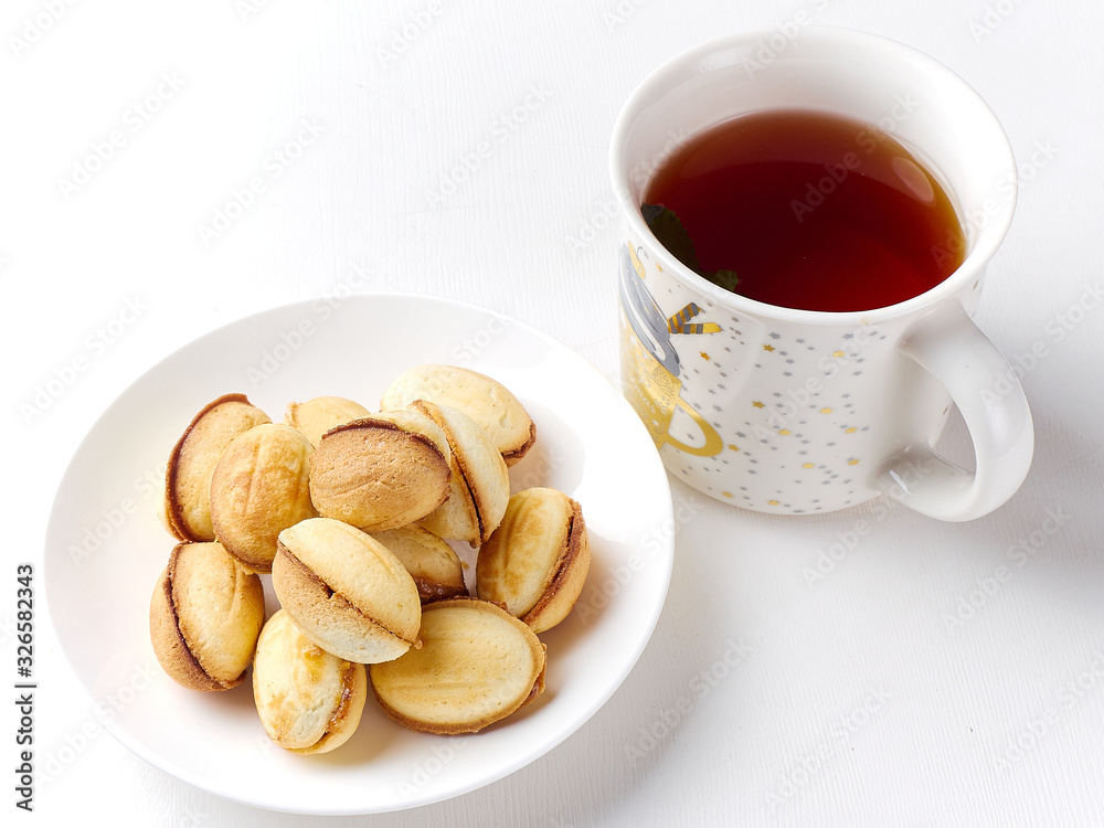 delicious walnut shaped shortbread sandwich cookies filled with sweet condensed milk and a mug of tea