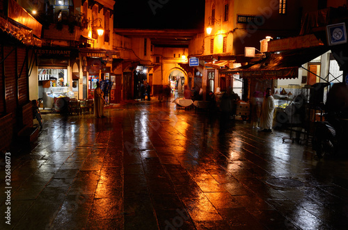 Cafes at Bab Boujeloud Blue Gate on a wet night in Fes el Bali Medina Morocco