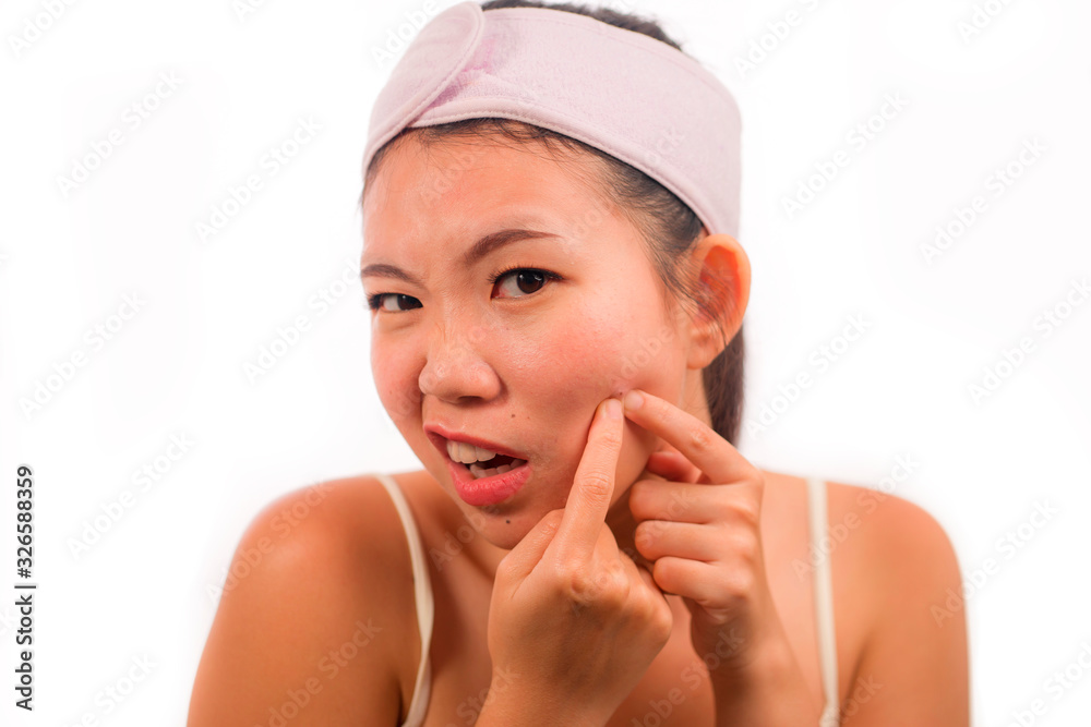 young beautiful angry and upset Asian Korean woman with acne pooping head of pimple with her fingers on the mirror cleansing the skin in beauty treatment concept isolated on white young beautiful angry and upset Asian Korean woman with acne pooping head of pimple with her fingers on the mirror cleansing the skin in beauty treatment concept isolated on white