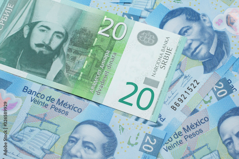 Fototapeta premium A close up of a green and white, twenty Serbian dinar bank note on a background of Mexican twenty peso bank notes