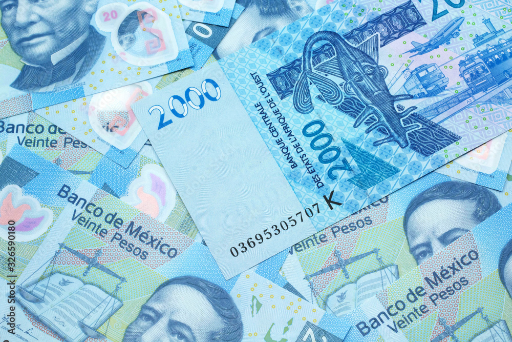 A close up image of a blue, two thousand, West African franc bank note in macro on a background of United States Mexican twenty peso bills