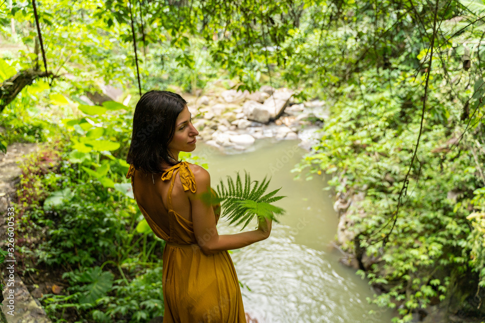 Relaxed brunette girl standing on hill over river Relaxed brunette girl standing on hill over river