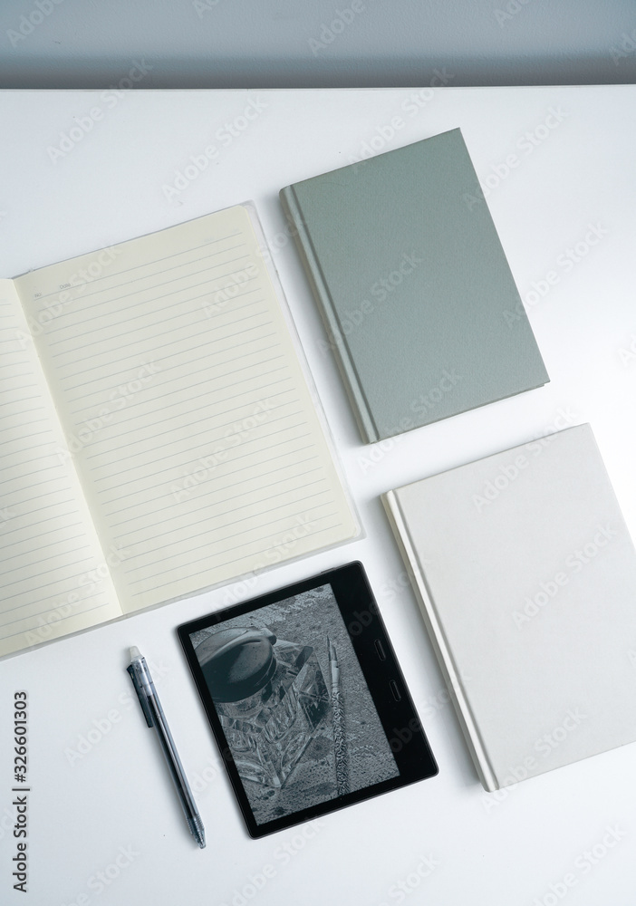 Fototapeta premium Books and notebooks and kindle eBooks on white desktop