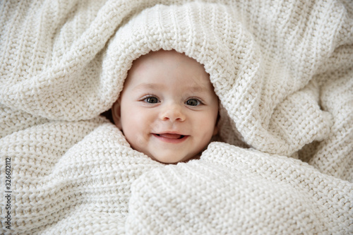 close up of happy baby wrapped in blanket