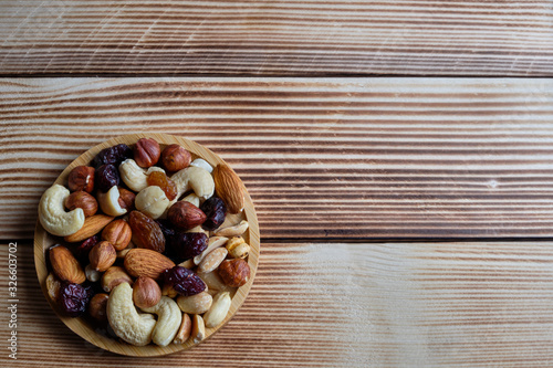 Mix of nuts and dried fruits at weathered wooden background