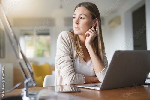 Portrait of woman at home conected with laptop photo