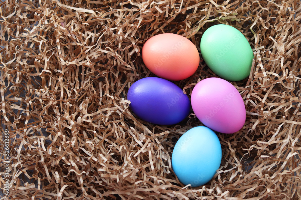 Easter multicolored eggs lie in the hay the decorative paper. selective focus. Easter still life Easter multicolored eggs lie in the hay the decorative paper. selective focus. Easter still life