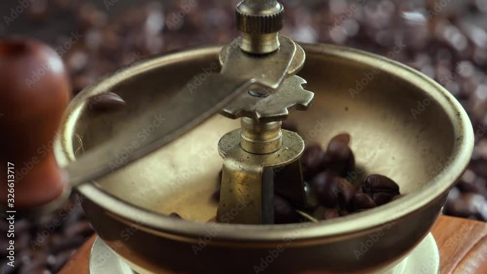 Roasted coffee beans slowly falling into the grinder 