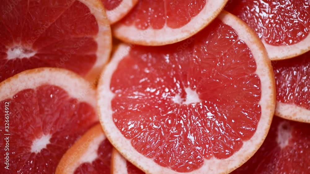 Grapefruit sliced half on rotating background. Citrus fruits. Vegan and raw food concept. Red grapefruits texture. Top view Grapefruit sliced half on rotating background. Citrus fruits. Vegan and raw food concept. Red grapefruits texture. Top view