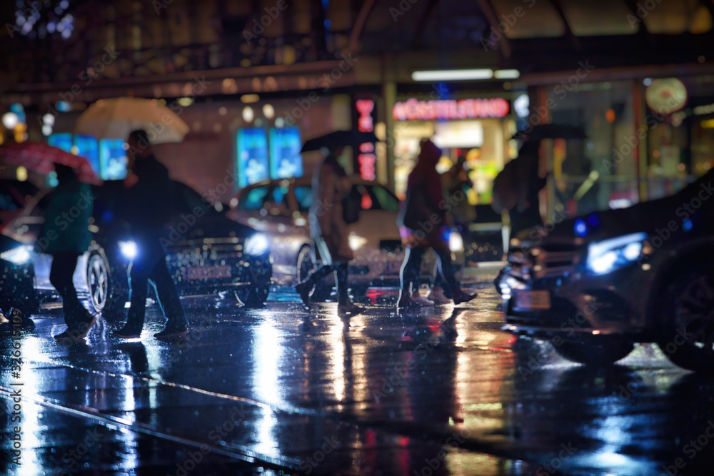 pedestrians walking on rainy night in the city vienna 