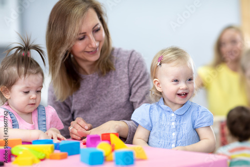 Nursery babies play with teacher in daycare