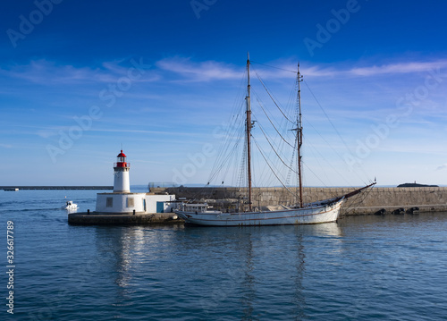 Lighthouse and sailboat docked in the port of the city of Ibiza, Bareares Islands, Spain