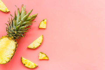 Pineapple - half of fruit and slices - on pink background top-down copy space