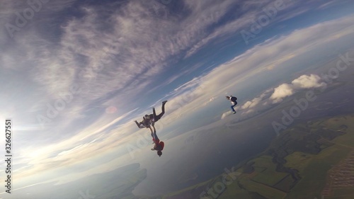 Artistic. Parachutist performs an acrobatic trick in the air. Flying men make professional jump. Extreme as a hobby. 