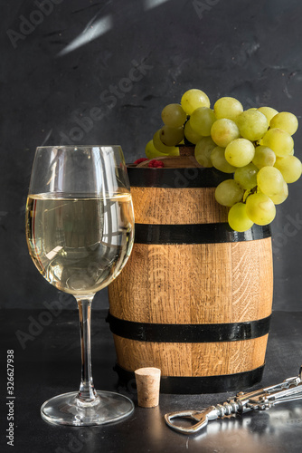 the still life with white wine, glass and old barrel