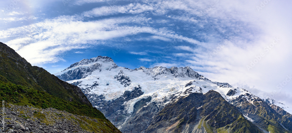 Panorama view the mueller glacier at kea point in Mount Cook National Park, the rocky mountains and green grasses of summer in New Zealand.