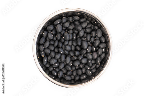 Dried Black Beans from above in a stainless steel bowl, isolated on a white background. Healthy ingredient used in soups and casseroles. Naturally preserved legumes with long shelf life.