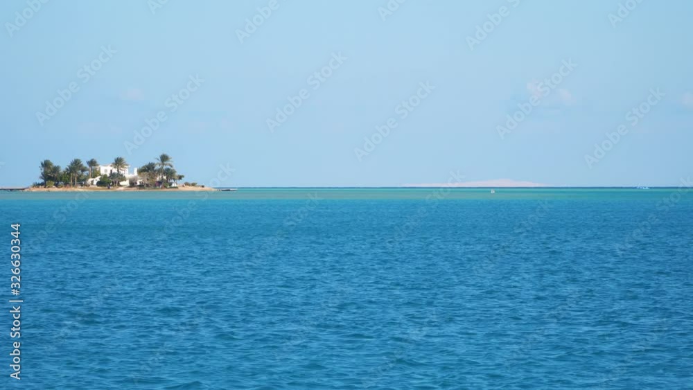 A small island with palm trees. View from a floating boat. Egypt Red Sea A small island with palm trees. View from a floating boat. Egypt Red Sea