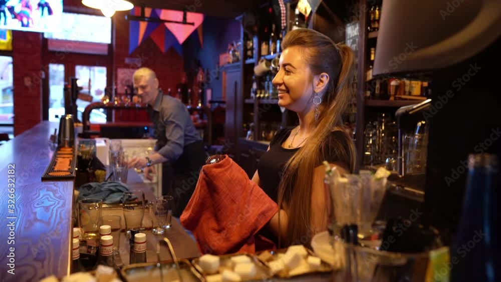 bartender and waitress work in bar behind counter