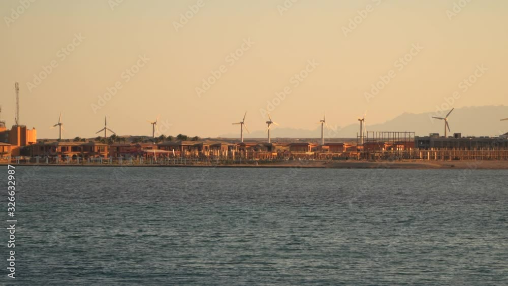 Egypt. Wind turbines on the coast. View from the sea from the ship. Evening time Egypt. Wind turbines on the coast. View from the sea from the ship. Evening time