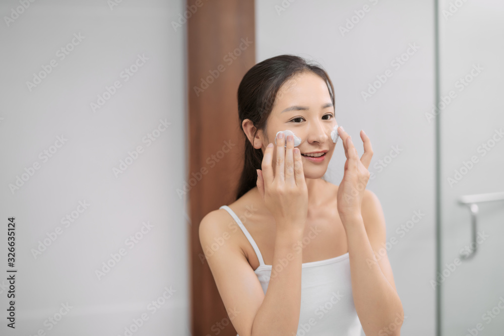 Beautiful young woman washing her face foam in a bathroom. Beautiful young woman washing her face foam in a bathroom.