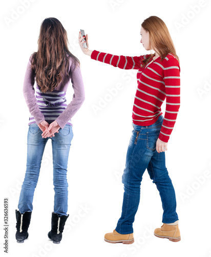 Back view of two woman with a mobile phone in sweater.