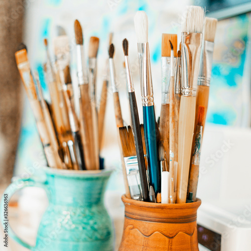 Tools and equipment for the artist. Palette and brushes close-up. The process of drawing and creativity. The picture is in blue.