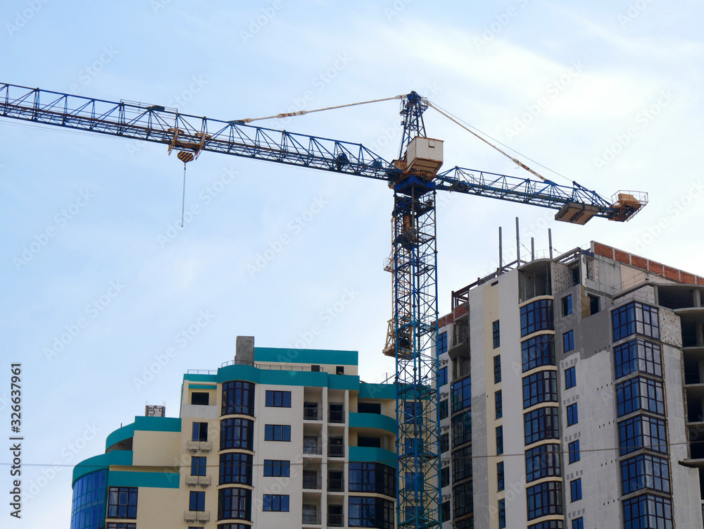 Construction crane near the building under construction. Construction site.