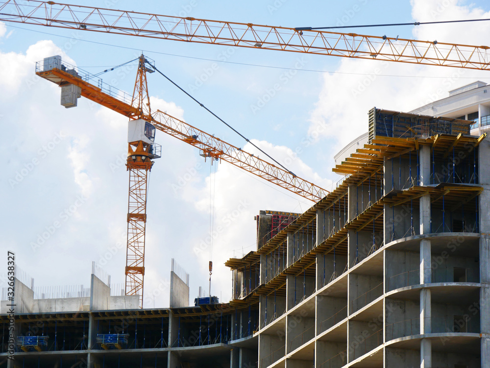 Construction site. High-rise multi-storey buildings under construction. Tower cranes near buildings. -